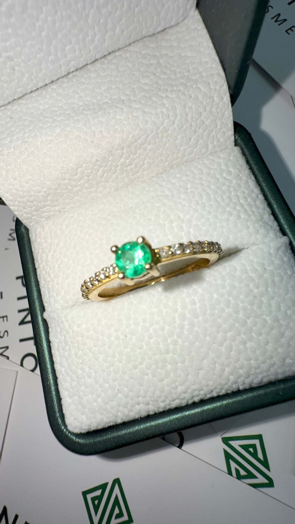 Anillo en Oro 18K con Esmeralda Central y Diamantes Laterales